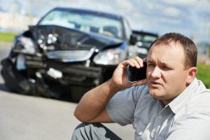Man on phone ringing insurance company after an accident for repair costs